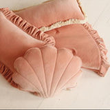 Pink shell-shaped cushions on a light wooden floor